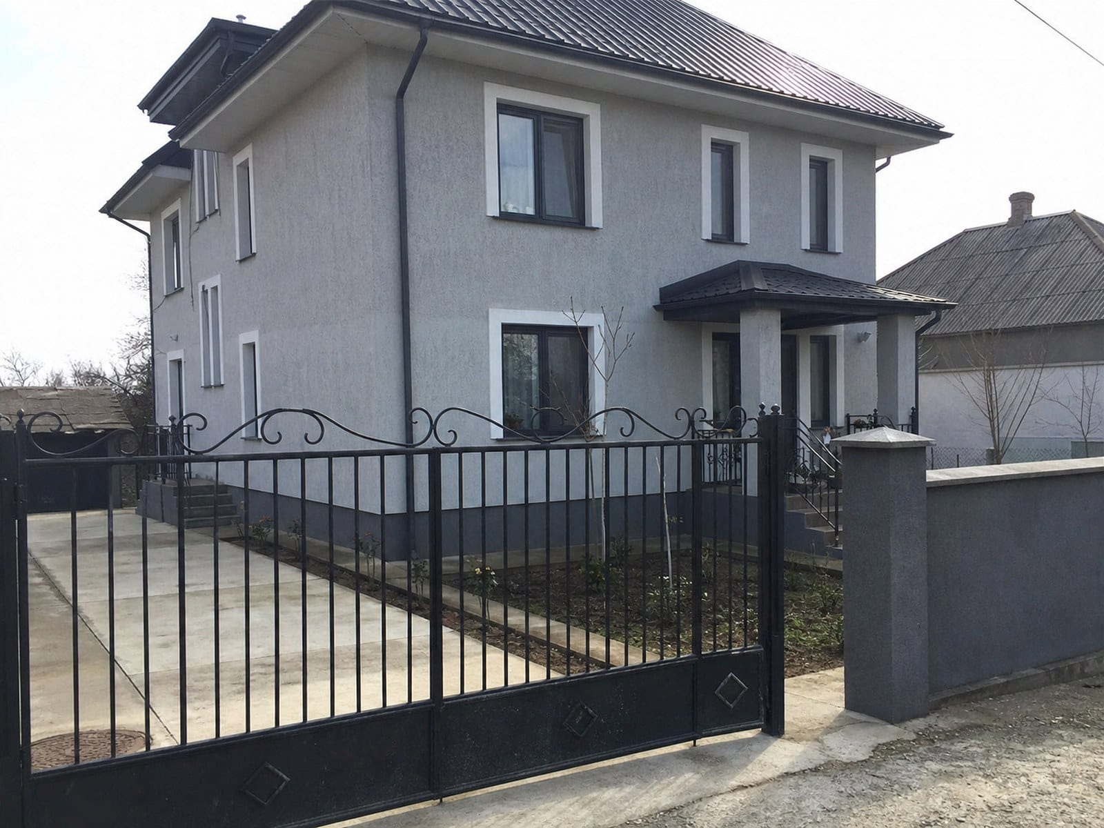 Vilă modernă în Durlești cu fațadă albă netedă și acoperiș închis la culoare