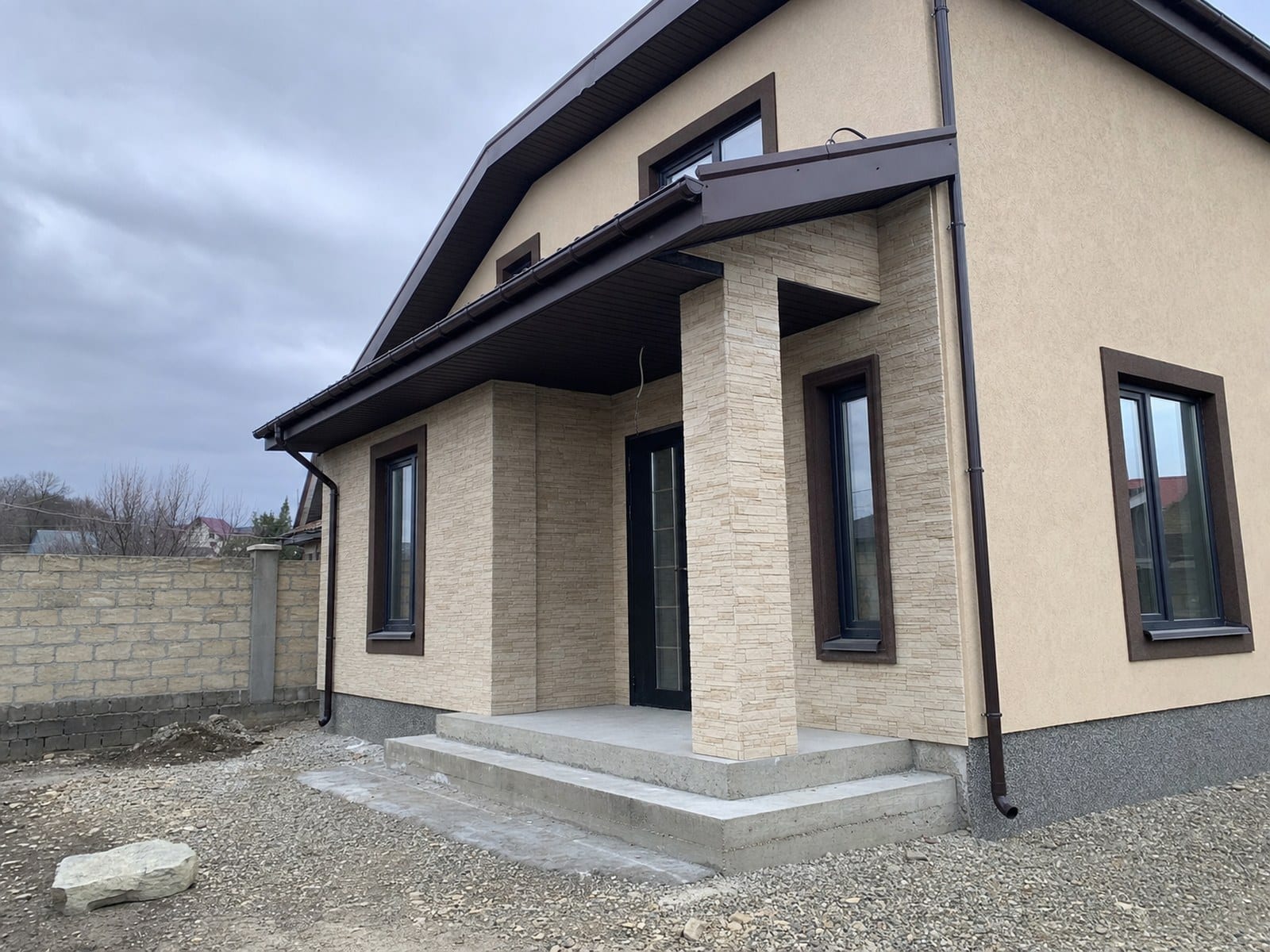 Casă în Ialoveni cu fațadă din piatră decorativă, tencuială și soclu finisat
